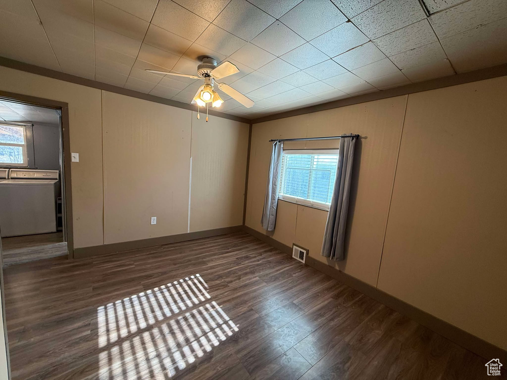 Spare room featuring ceiling fan, ornamental molding, washer / clothes dryer, and dark hardwood / wood-style flooring