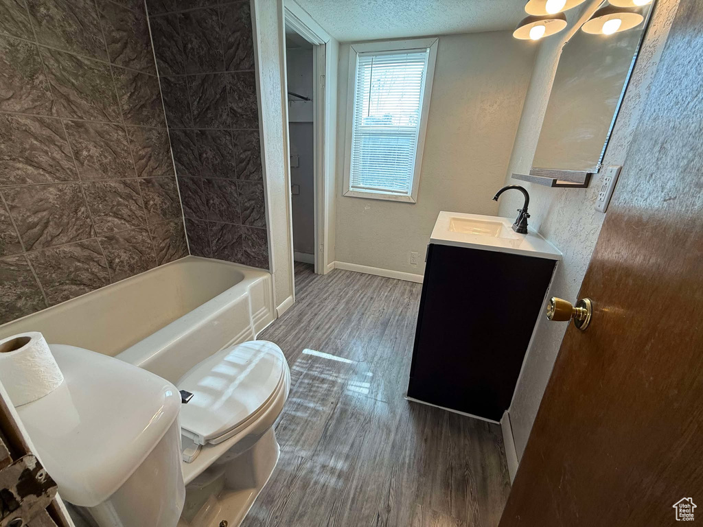 Full bathroom featuring vanity, wood-type flooring, bathtub / shower combination, and toilet