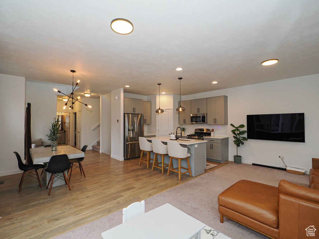 Living room featuring a chandelier, sink, and light hardwood / wood-style flooring