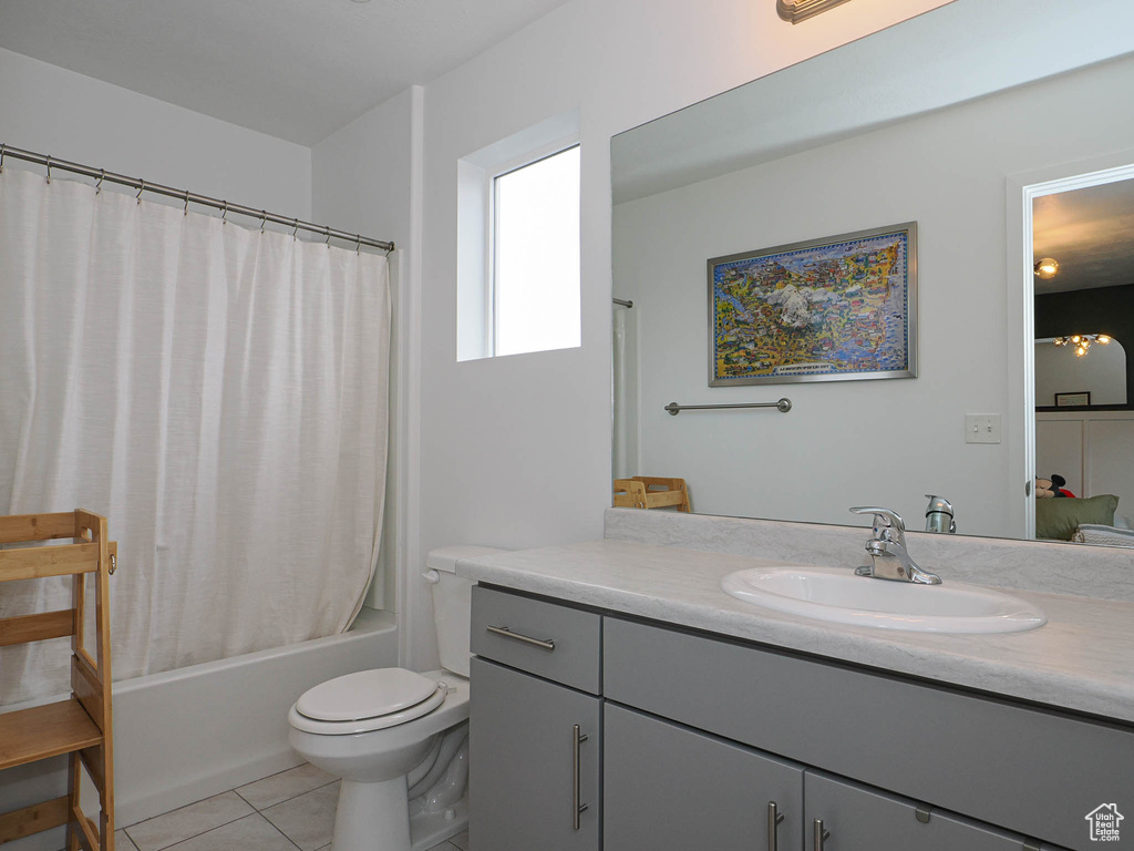 Full bathroom featuring tile patterned floors, shower / bathtub combination with curtain, vanity, and toilet