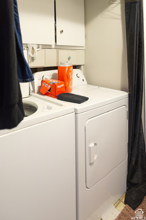 Laundry area with separate washer and dryer and cabinets