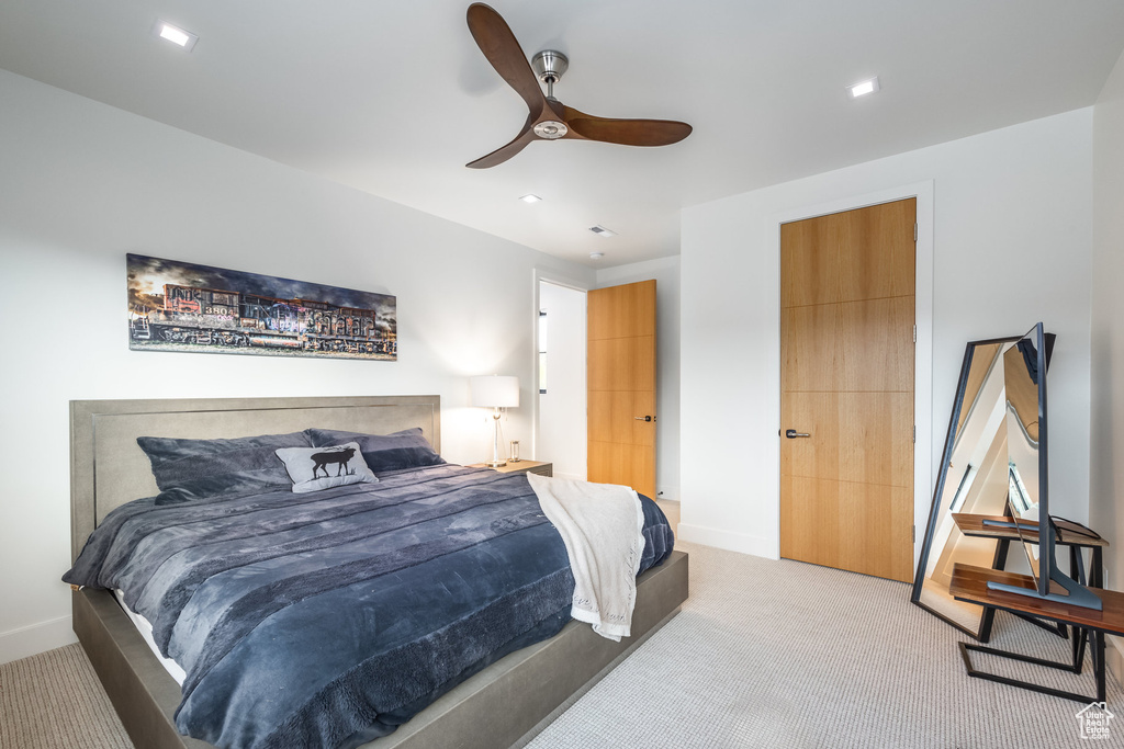 Carpeted bedroom featuring ceiling fan