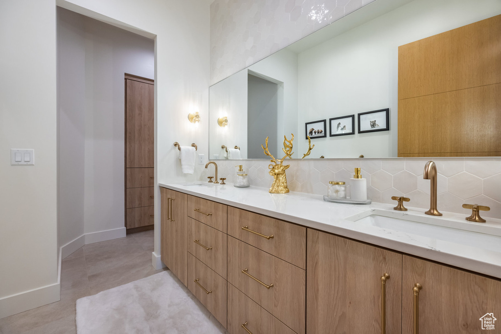 Bathroom with vanity and tasteful backsplash