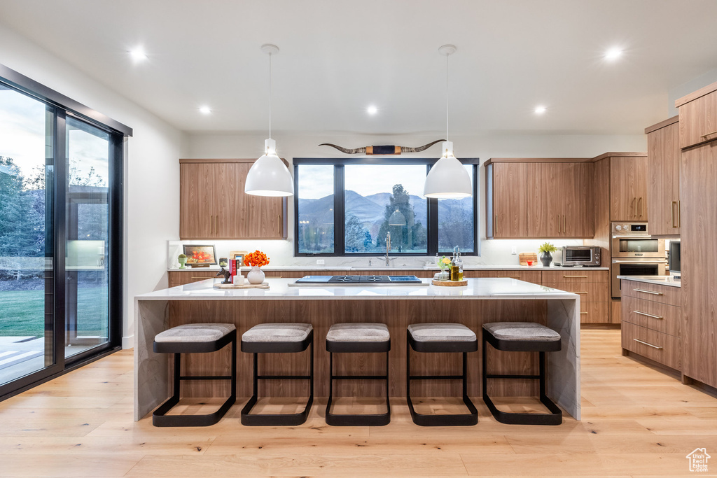 Kitchen featuring a wealth of natural light, hanging light fixtures, and a large island