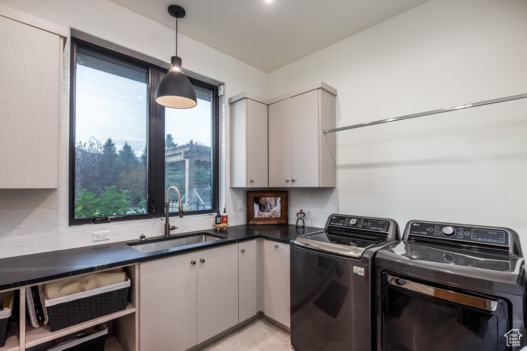 Laundry area with cabinets, sink, and washing machine and clothes dryer