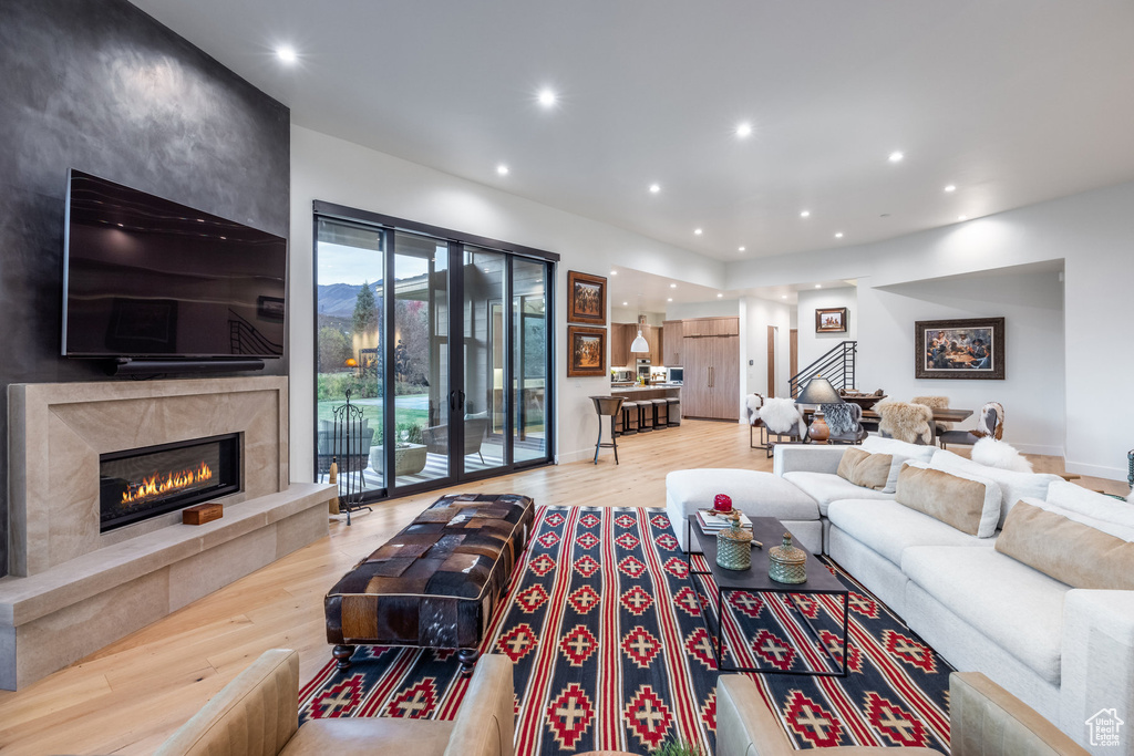 Living room with a fireplace and light hardwood / wood-style flooring