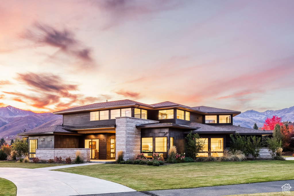 Prairie-style home with a lawn and a mountain view