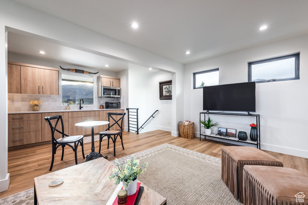 Living room with light hardwood / wood-style floors and sink