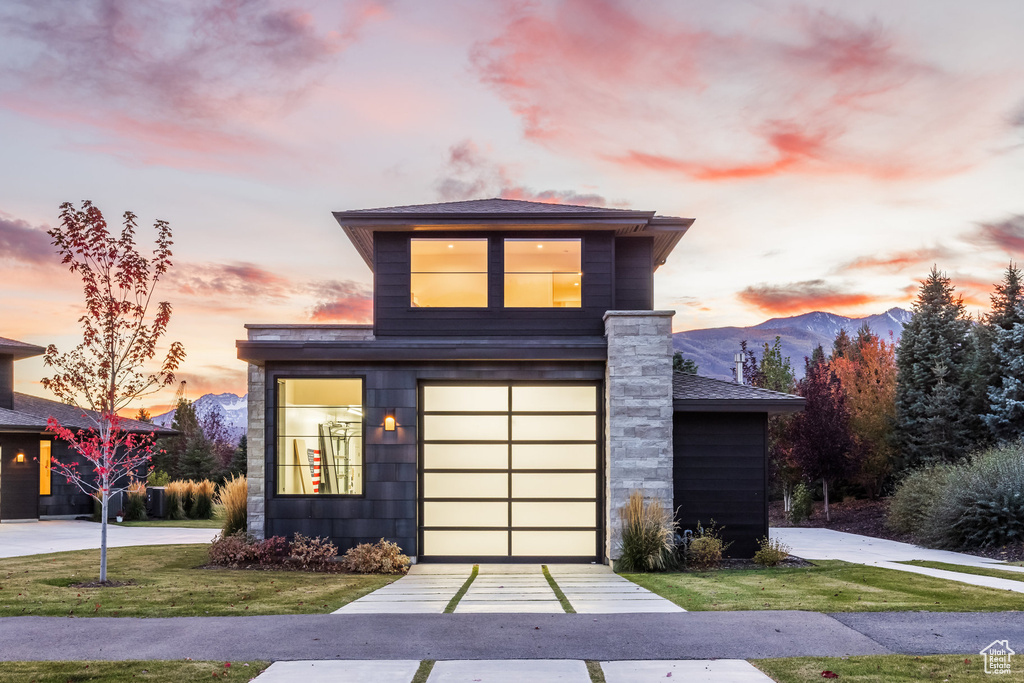 Contemporary home with a lawn, a mountain view, and a garage