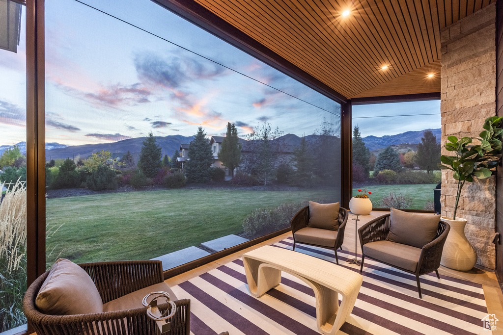 Sunroom / solarium with a mountain view and wooden ceiling