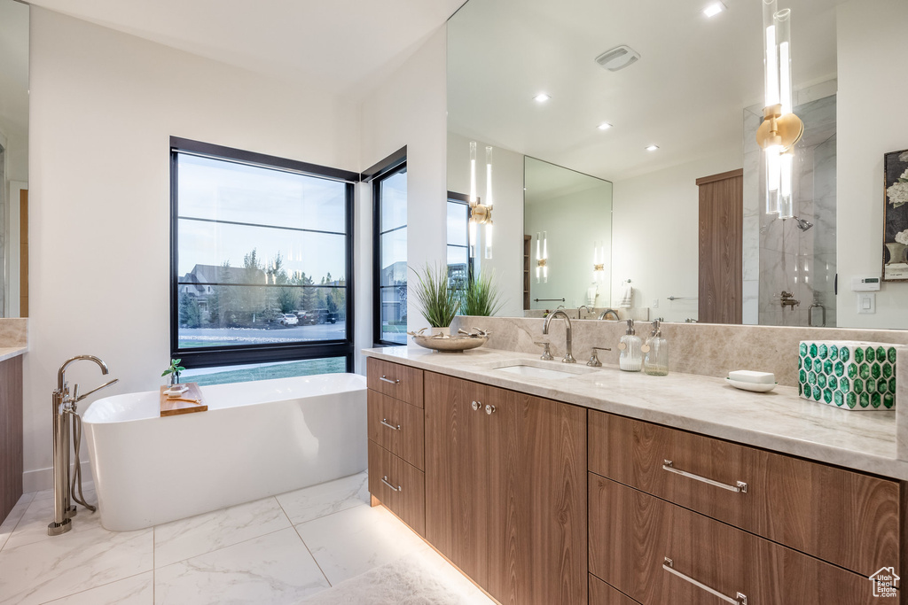 Bathroom featuring vanity and separate shower and tub