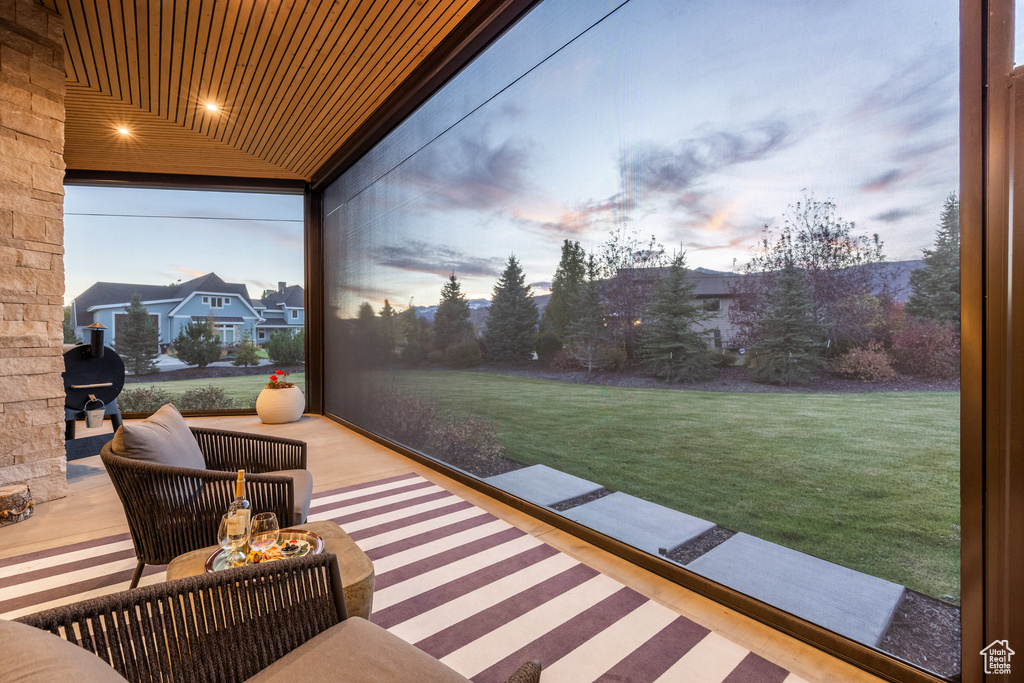 Patio terrace at dusk with an outdoor living space and a yard