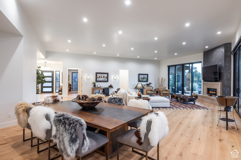 Dining area with a large fireplace, a healthy amount of sunlight, and light hardwood / wood-style floors