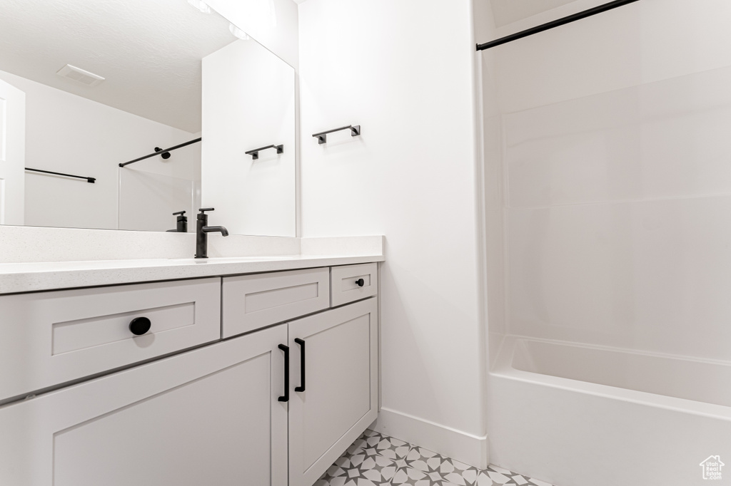 Full bath featuring visible vents, baseboards, tile patterned floors, vanity, and shower / bath combination