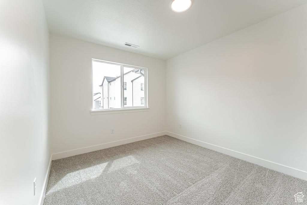 Unfurnished room featuring carpet floors, baseboards, and visible vents