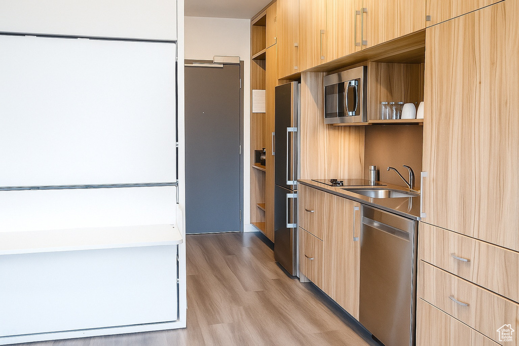 Kitchen with stainless steel appliances, open shelves, and light brown cabinetry