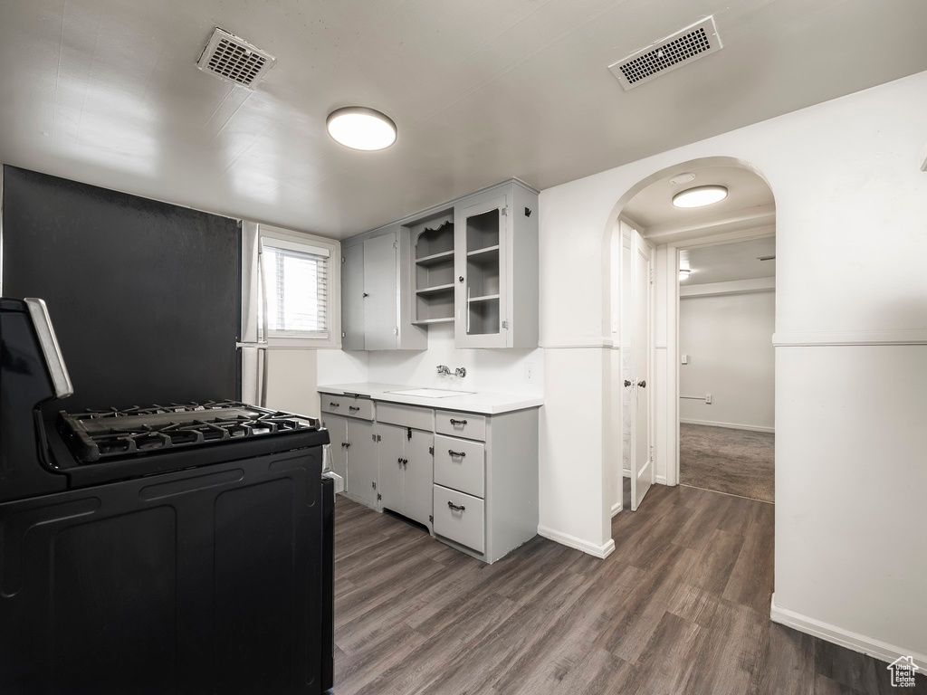 Kitchen featuring gas stove, sink, and dark hardwood / wood-style floors