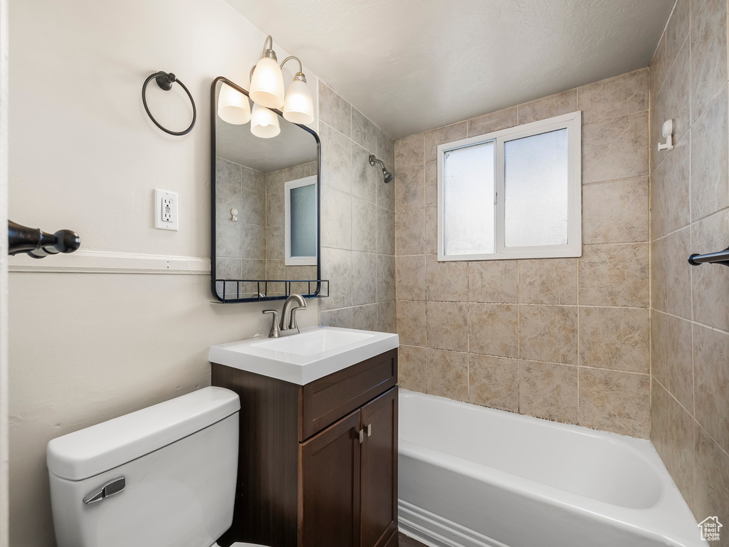 Full bathroom featuring vanity, toilet, and tiled shower / bath combo