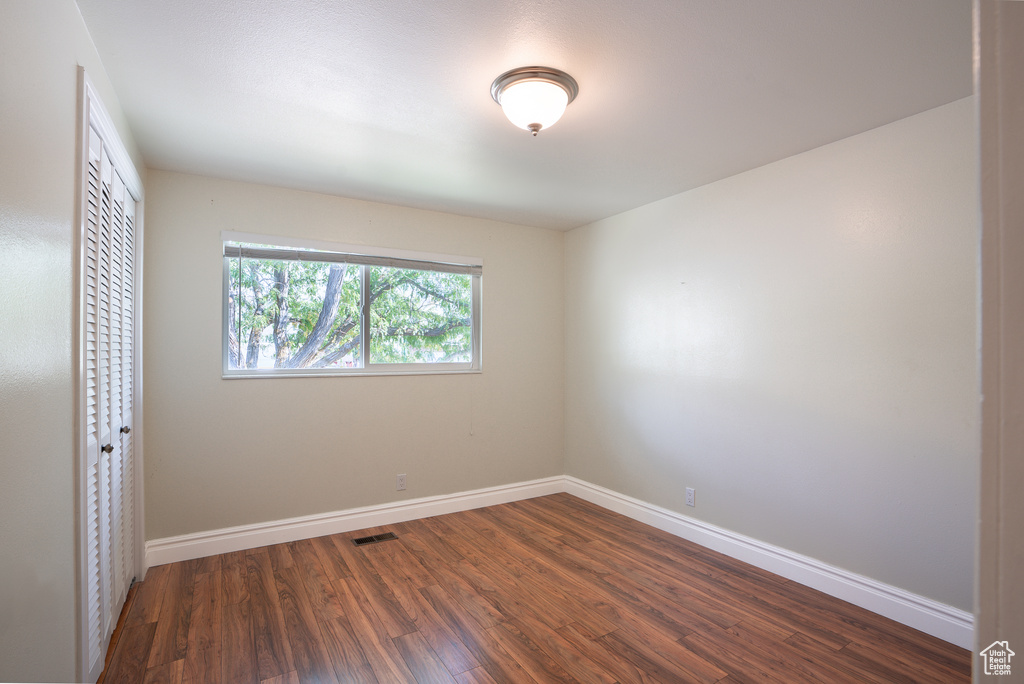 Empty room with dark hardwood / wood-style flooring