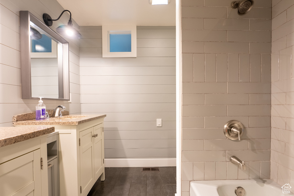 Bathroom featuring vanity and tiled shower / bath