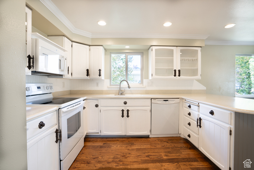 Kitchen with sink, dark hardwood / wood-style flooring, white appliances, white cabinets, and ornamental molding