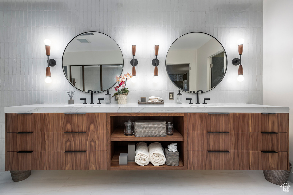 Bathroom with vanity and tile walls