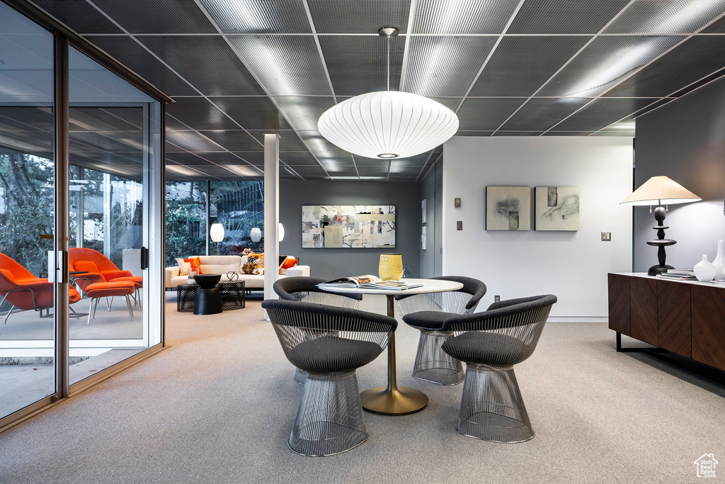 Carpeted dining space featuring floor to ceiling windows