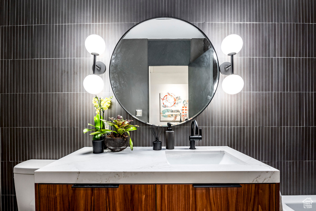 Bathroom featuring vanity and tile walls