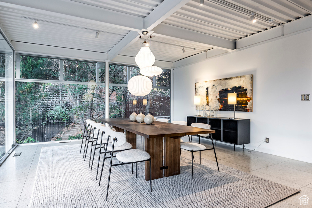 Dining space featuring beamed ceiling, expansive windows, and a wealth of natural light