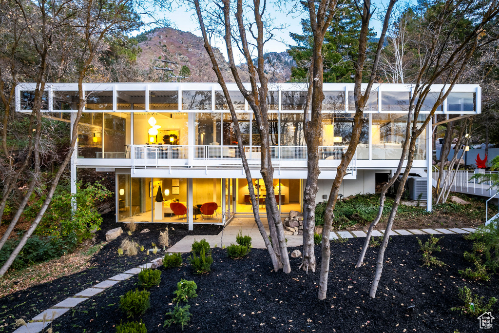 Rear view of property featuring a mountain view, a patio, and a balcony