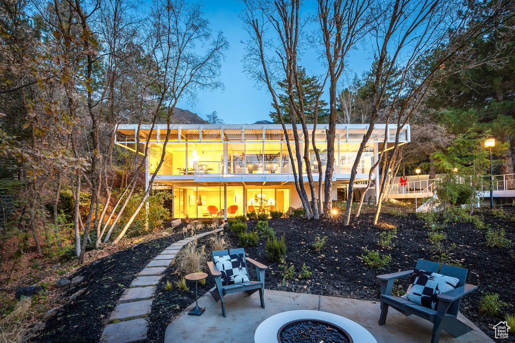 Rear view of property with a balcony, an outdoor fire pit, and a patio