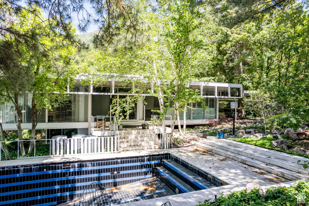 View of swimming pool with a sunroom