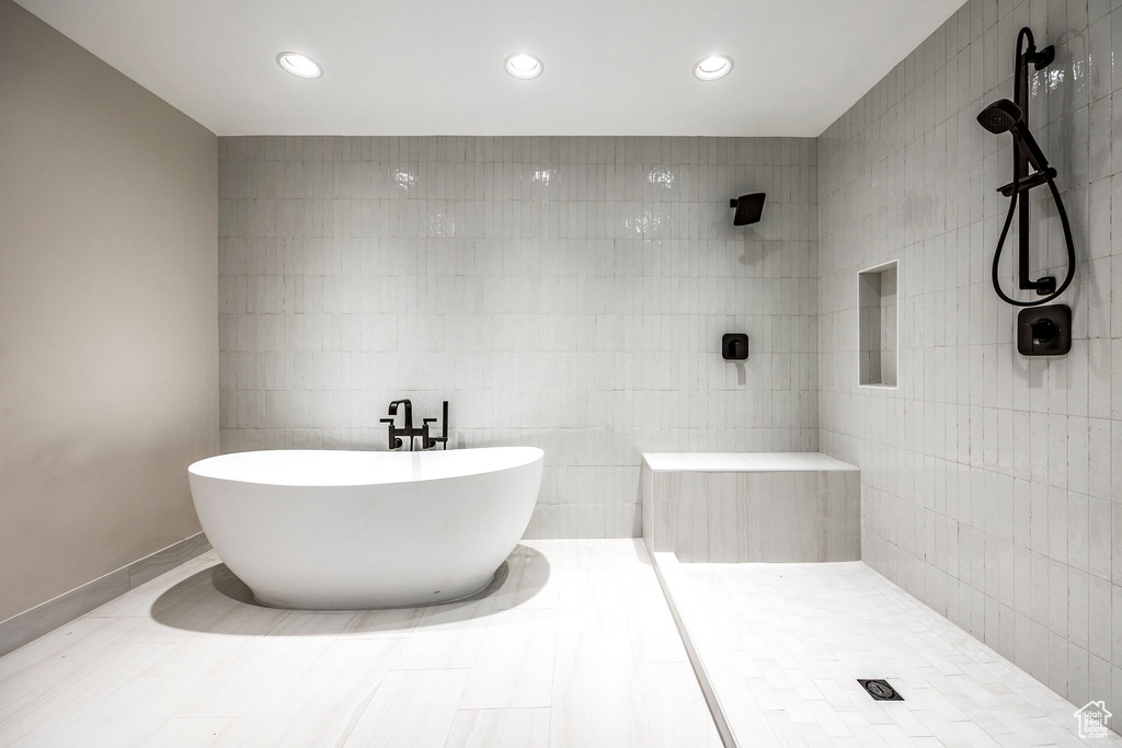 Bathroom with independent shower and bath and tile walls