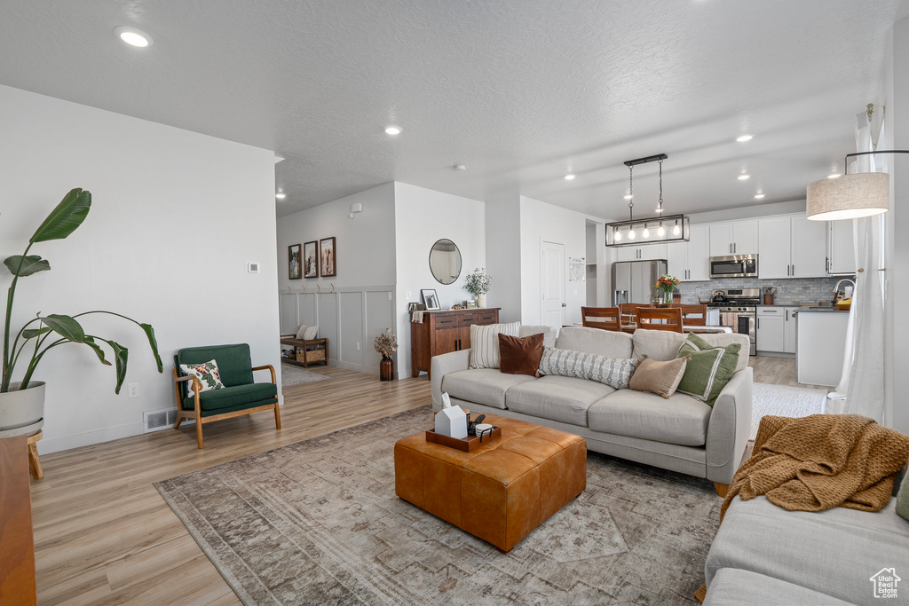 Living room featuring light hardwood / wood-style floors and a textured ceiling