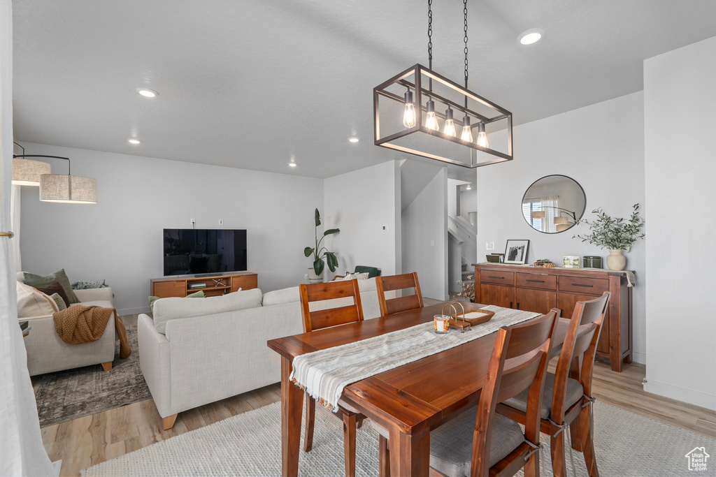 Dining area with light hardwood / wood-style floors and a chandelier