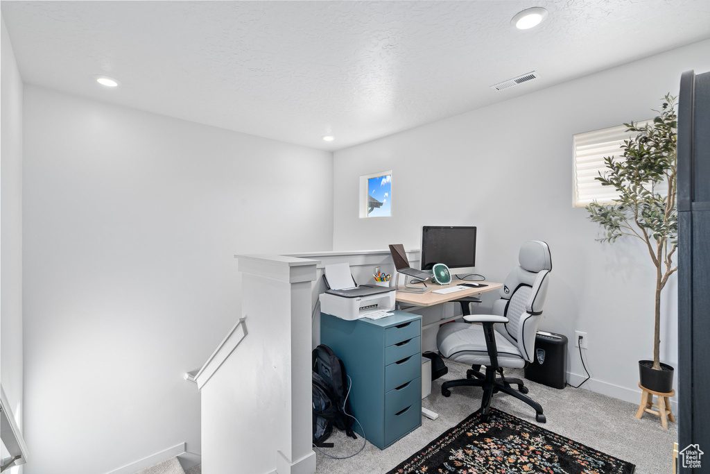 Carpeted office space with a textured ceiling