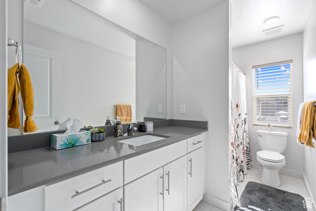 Bathroom with tile patterned flooring, vanity, and toilet