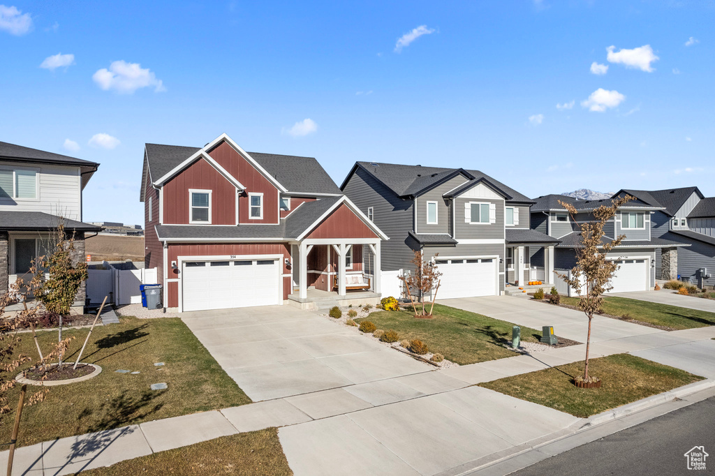 Multi unit property with a porch, a garage, and a front lawn