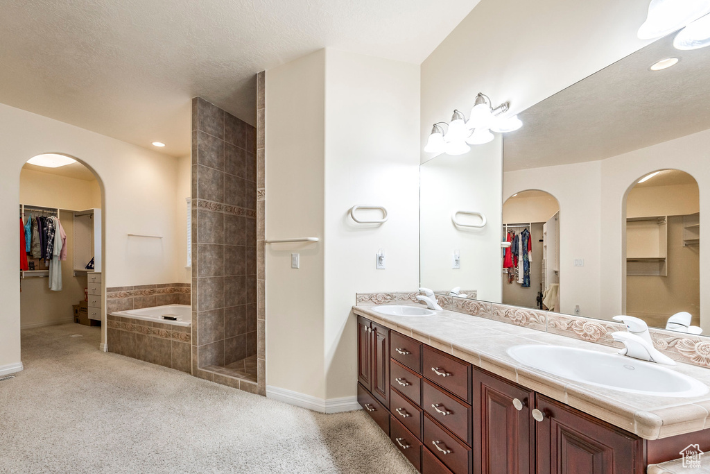 Bathroom with plus walk in shower, a textured ceiling, and vanity