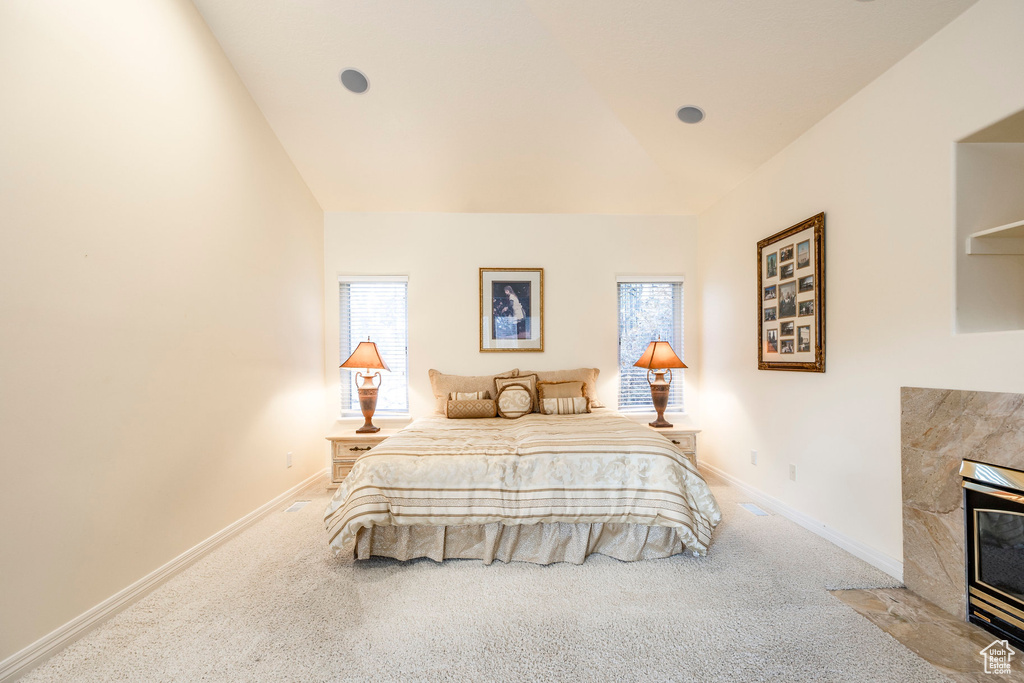 Bedroom featuring carpet, vaulted ceiling, and multiple windows