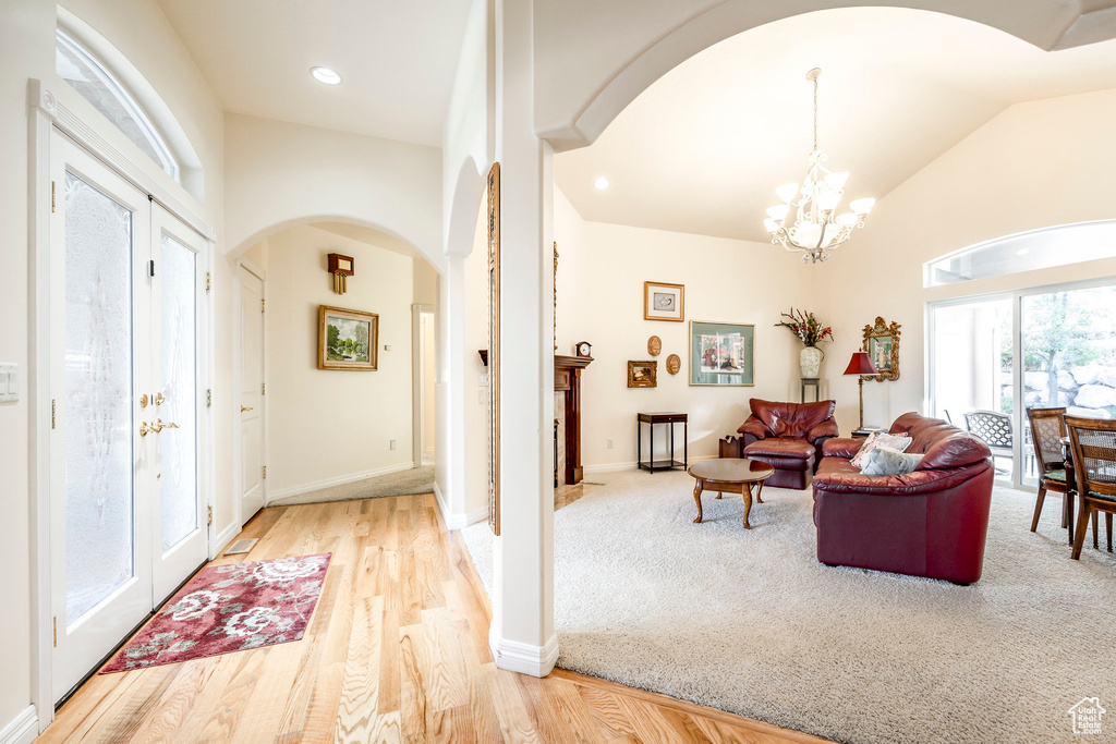 Foyer featuring a chandelier, lofted ceiling, and light wood-type flooring