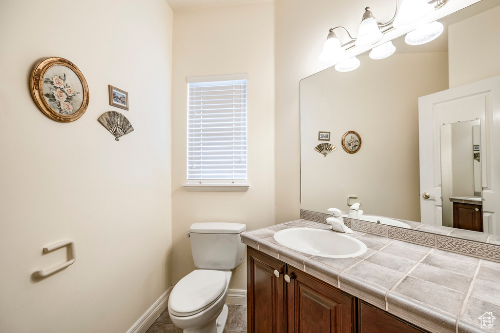 Bathroom featuring tile patterned flooring, vanity, and toilet