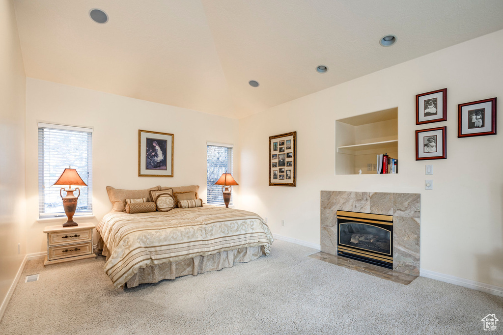 Carpeted bedroom featuring a tile fireplace