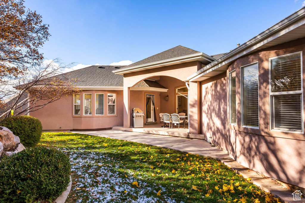 Rear view of property featuring a lawn and a patio