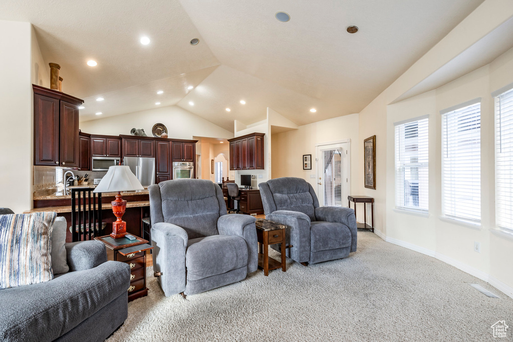 Carpeted living room featuring lofted ceiling