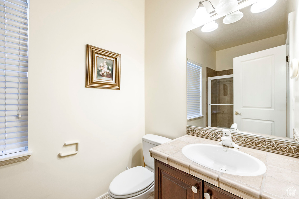 Bathroom with walk in shower, vanity, and toilet