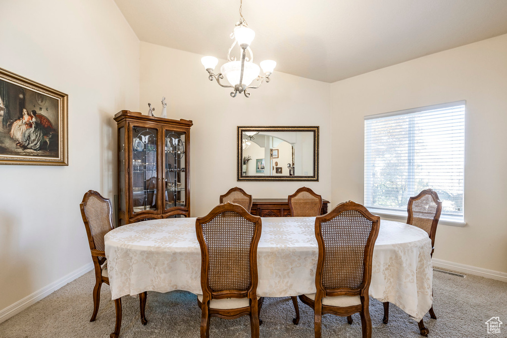 Carpeted dining room featuring a chandelier