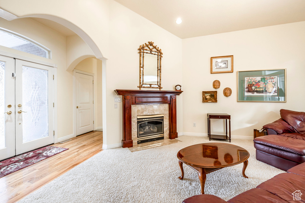 Living room with a fireplace, french doors, and light hardwood / wood-style floors