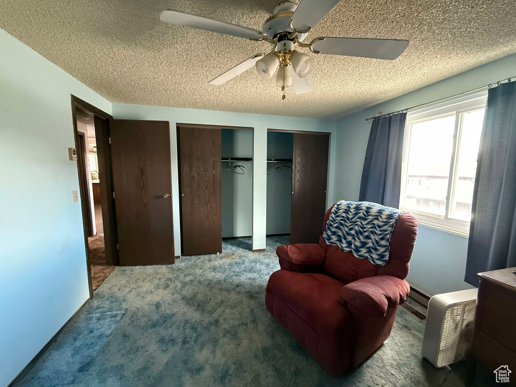 Sitting room featuring ceiling fan, carpet floors, and a textured ceiling