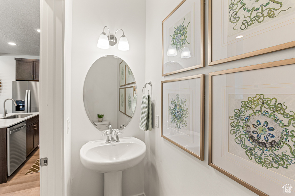 Bathroom featuring wood finished floors, recessed lighting, and a textured ceiling